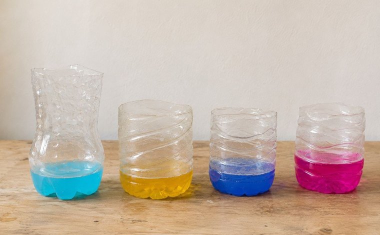 Coloured water in cut plastic bottles on a table