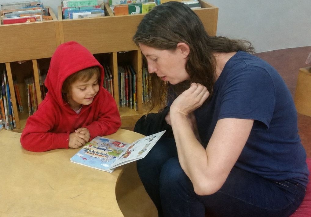 Michal Reshef reading a picture book with a child
